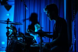 A man playing a set of drums in a band.