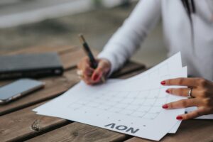 A woman working on filling out a busy calendar.